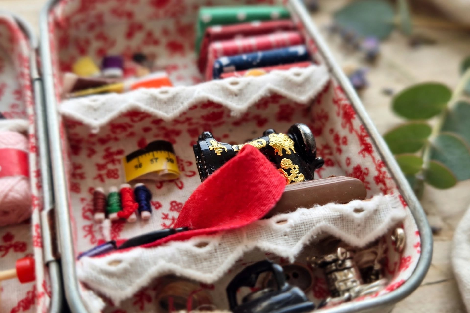 Caixa de costura em diorama com máquina de costura e linhas, ao perto