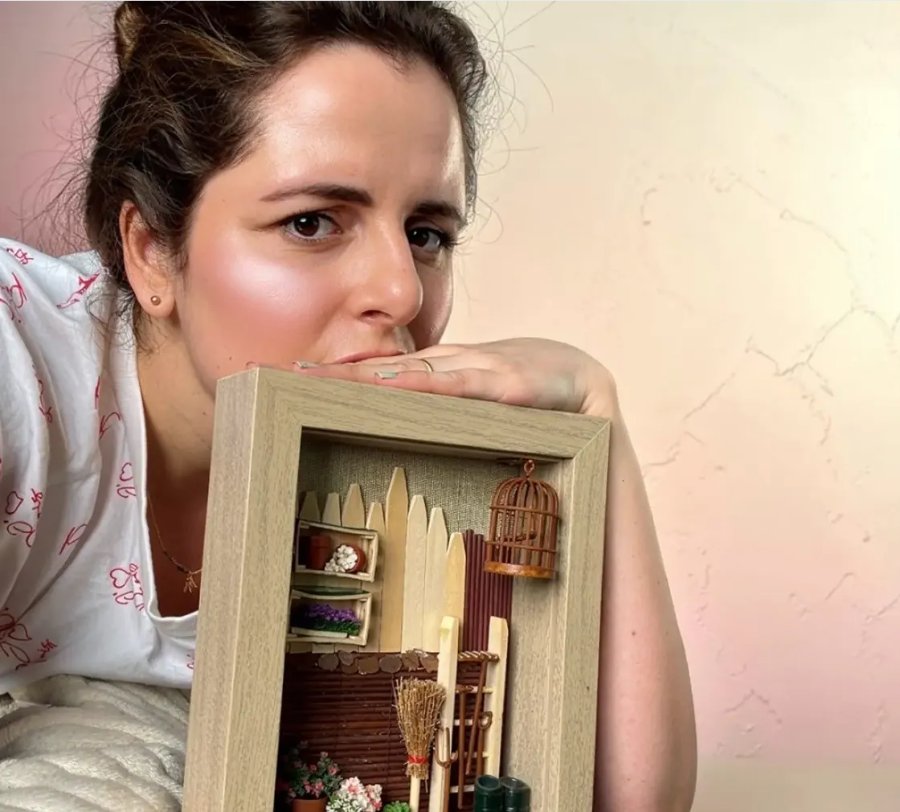 Silvia com um diorama em moldura de madeira